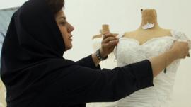 Woman adjusts a wedding dress in a shop in tehran (file photo)