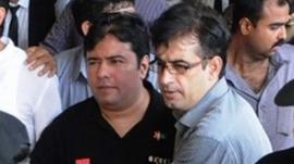 Pakistani security officials escort Axact Chief Executive Shoaib Shaikh (left|)