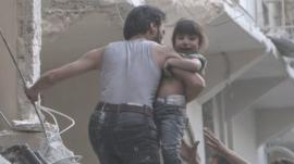 A man evacuates a child from a building following a reported barrel bomb attack by Syrian government forces on the northern Syrian city of Aleppo, on May 30, 2015. Barrel bombs dropped from regime helicopters killing more than 70 civilians in Aleppo, while government forces in neighbouring Iraq retook an area west of the jihadist-controlled city of Ramadi. AFP PHOTO / KARAM AL-MASRI