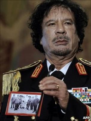 Col Gaddafi wears a picture depicting the execution of Omar al-Mukhtar in <b>...</b> - _51870910_011491894-1