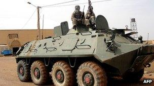 Fighters of the Islamist Movement for Unity and Jihad pose an abandoned Malian army tank in the northern town of Gao on 8 August 2012 (file picture)