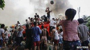 Ethnic Rakhine people get water from a fire truck to extinguish fires during fighting between Buddhist Rakhine and Muslim Rohingya communities in Sittwe, 10 June 2012