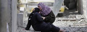 Two Palestinian women cry upon their return to the family house destroyed by Israeli strikes in Beit Hanoun, northern Gaza Strip, 26 July 2014
