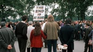 A man with a sign saying THE END IS AT HAND talks to the crowd at Speakers' Corner, Hyde Park, London on 11 June 1972.