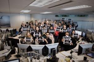 AFP staff hold up "I am Charlie" placards at the French news agency's Hong Kong office, 8 January