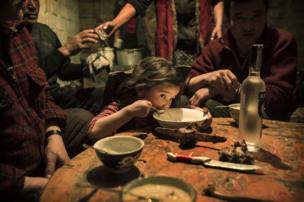 Herder Shohan's family enjoy a last family meal before they separate - copyright Timothy Allen