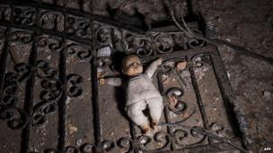 A doll on the ground at the entrance to a destroyed house following clashes between Macedonian police and an armed group in Kumanovo on 10 May 2015