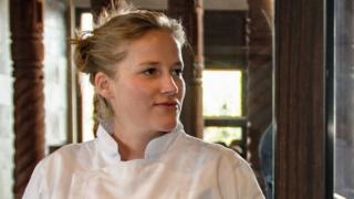 chef habla con un cocinero en medio de una cocina