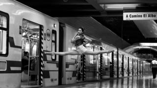 Image shows woman do splits in the air at railway station