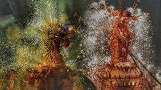 Image shows wooden dragons lit with sparks and fire