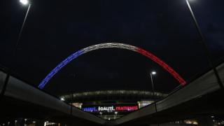 The arch of London"s Wembley Stadium is illuminated with the colours of the French national flag and the motto Liberte