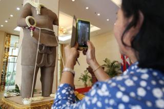 A Cambodian takes a picture of a Khmer statue on display during a ceremony in Phnom Penh, Cambodia, 28 March 2016