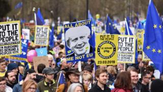 Protesters hold a placard showing a picture of Boris Johnson with the words 'All about me not EU' during the Put It To The People March on March 23, 2019 in London, England.
