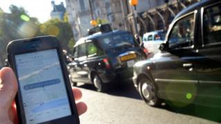 Taxi-based app in front of traditional black cabs