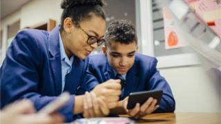 deux étudiants regardant un téléphone portable