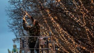In Berlin, the capital of Germany, a worker is putting the lights on the tress of the famous central main street, Unter den Linden,
