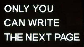 A-strip-light-sign-in-white-reads-only-you-can-write-the-next-page.