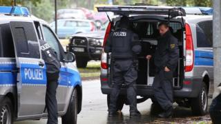 In this image taken from Nonstop News video, police officers surround an apartment in the eastern city of Chemnitz, Germany, Saturday Oct. 8, 2016