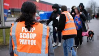 Woman in poop scoop patrol jacket
