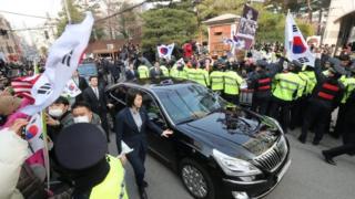Police contain supporters of Park Geun-hye as she leaves in a car her home in Seoul. Photo: 21 March 2017