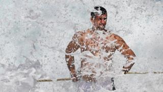 A swimmer at the Bronte ocean pool is hit by waves as large seas pound the coast at Bronte Beach in Sydney on March 6, 2017