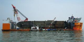 In this handout photo released by the South Korean Ministry of Oceans and Fisheries, the sunken ferry Sewol is seen on its side on a semi-submersible transport vessel during the salvage operation in waters off Jindo, South Korea, 28 March 2017.