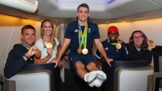 Pete Reed, Helen Glover, Max Whitlock, Nicola Adams and Katie Archibald pose for a picture on the flight home