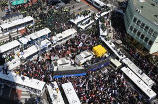 朴槿惠的支持者在樸被彈劾後試圖衝過警方的巴士防線，朝憲法法院方向進發。