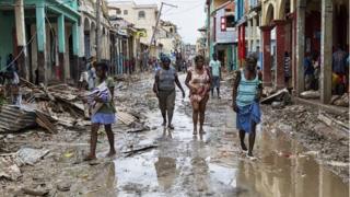 People walking down a flooded street in the town of Jeremie, Haiti on 6 October 2016