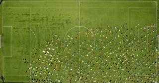 many people praying on football pitch