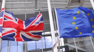 The British Union flag and the EU flag fly from flag poles in London