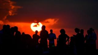 People gather as they wait for the sun to go down and the appearance of the "Blood moon" in Berlin on July 27, 2018. The "Blood moon" total lunar eclipse, is the longest of the 21st century.
