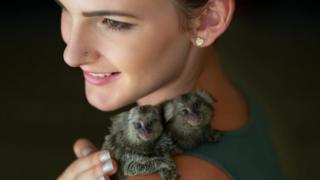 Woman holding pygmy marmosets