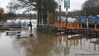 Flooding at tables and benches at by a canal