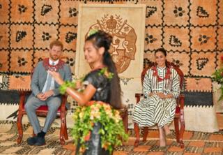 Harry and Meghan watch a young woman performing a dance