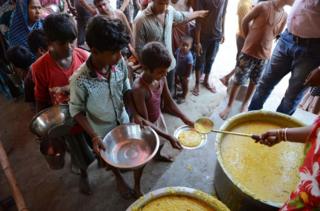 Indian villagers queue for food