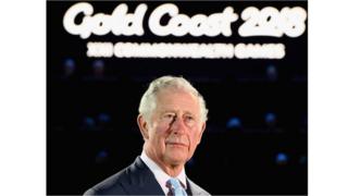 Prince Charles reads out the Queen's message underneath a sign that says 'Gold Coast 2018'.