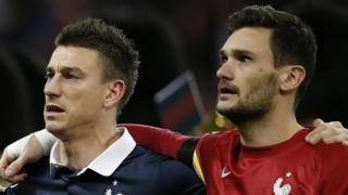 France"s goalkeeper and captain Hugo Lloris (R) and France"s defender Laurent Koscielny sing their country"s national anthem