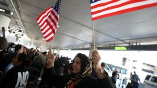 A protester waves American flags during a demonstration against the immigration ban in January 2017 in Los Angeles, California