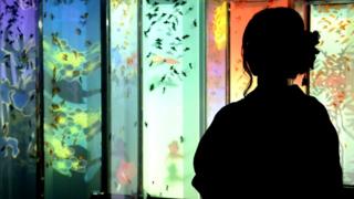 Mujer frente a un acuario