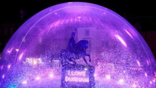 a-statue-of-a-man-on-a-horse-in-a-giant-snow-globe.