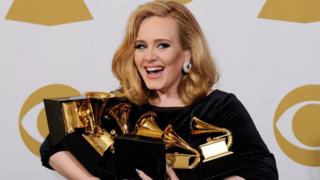 Adele holding lots of awards
