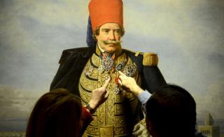 Visitors point at a painting bearing a portrait of former Tunisian ruler from the Husainid Dynasty Muhammad III as-Sadiq during an exhibition at the Ksar Saad Palace in the suburbs of Tunis.