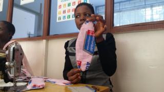Une employée de l'ONG Sacode montre à la correspondante de BBC Afrique une serviette "agateka".