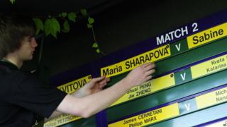 A member of the ground staff puts up the order of play