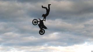 A motorcyclist from The Extreme Stunt Show takes part in a performance at Earsdon, North Tyneside, during their UK tour.