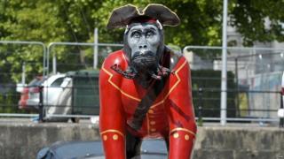 Life-size gorilla sculptures on top of a boat in Bristol.