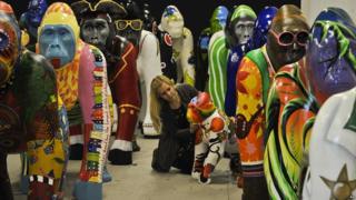 Colourful, life-size gorilla sculptures with worker from Bristol Zoo.