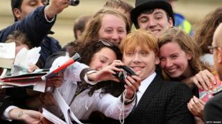 Rupert Grint having his photograph taken with a fan