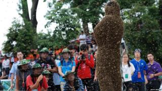 People taking photos of bee keeper Wang Dalin during the contest in China